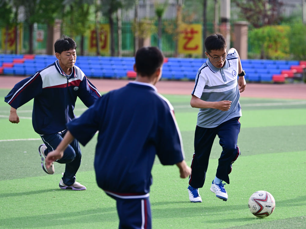 2024年6月18日，在位于青海省西宁市城北区的果洛西宁民族中学，学生们在踢足球。