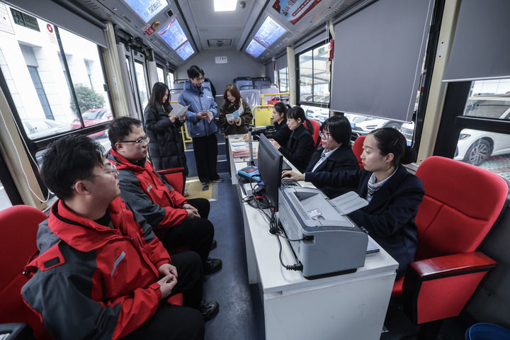 浙江省嘉兴市南湖区政务服务中心政务服务大篷车来到浙江凯乐士科技集团股份有限公司，企业员工在车上咨询社保、医保、人才等方面政策（2025年2月25日摄）。