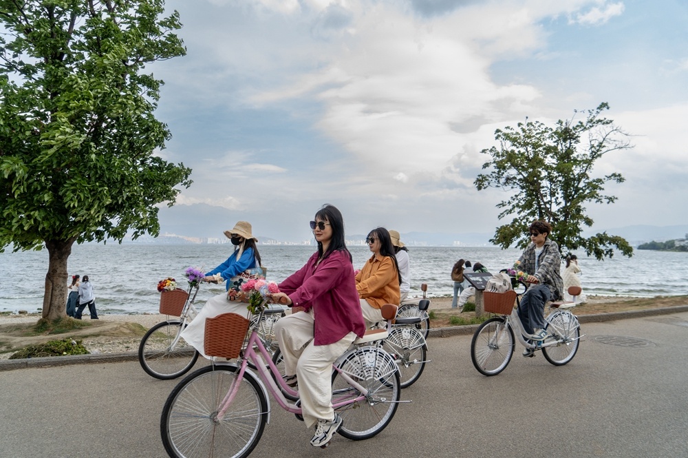 游客在云南大理洱海生态廊道骑行（2025年4月23日摄）。
