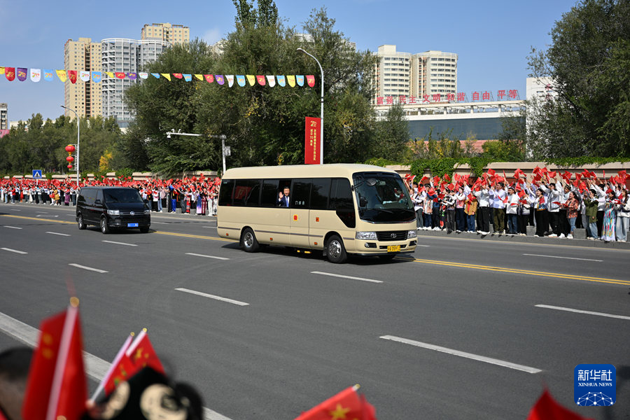9月23日下午，中共中央总书记、国家主席、中央军委主席习近平率中央代表团乘专机抵达乌鲁木齐，出席新疆维吾尔自治区成立70周年庆祝活动。这是从机场到住地途中，习近平向沿途欢迎的群众挥手致意。