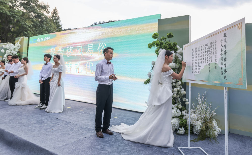 2025年8月20日,在浙江省诸暨市东白湖镇斯宅村举行的集体婚礼上,新人在移风易俗倡议上签名。 2025年8月20日,在浙江省诸暨市东白湖镇斯宅村举行的集体婚礼上,新人在移风易俗倡议上签名。