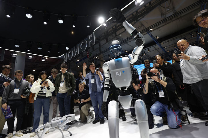 2025年3月3日，在西班牙巴塞罗那举行的2025年世界移动通信大会上，人们在荣耀展区参观拍摄演示机器人。
