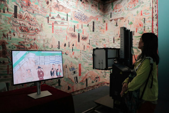 在敦煌研究院“典范”“高地”建设成果展上,游客参观莫高窟壁画高保真自动拍摄装置(2024年9月22日摄)。 在敦煌研究院“典范”“高地”建设成果展上,游客参观莫高窟壁画高保真自动拍摄装置(2024年9月22日摄)。