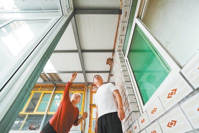每逢雨季，李建锋会去独居老人家里查看漏雨情况，方便及时修补。