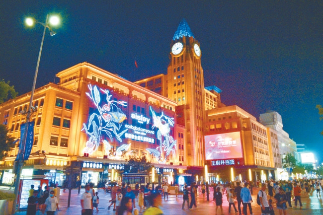 7月26日晚，夜色降临的王府井大街上人流如织，百货大楼、王府中环等商场灯火通明。
