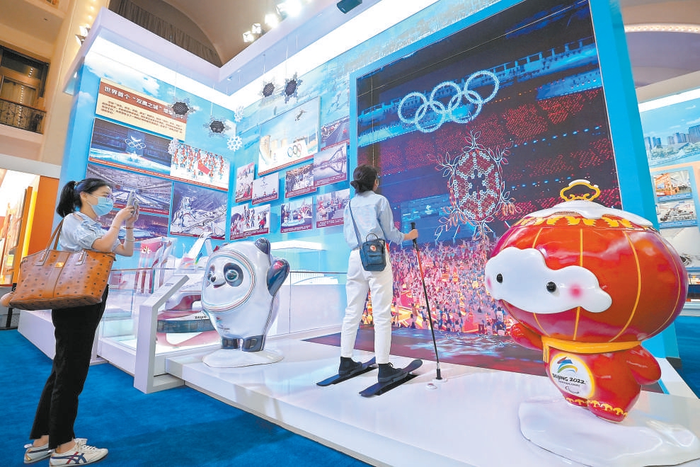 图为“奋进新时代”主题成就展北京展区。在北京冬奥会和冬残奥会吉祥物冰墩墩、雪容融打卡点，参观者纷纷前来拍照留念。