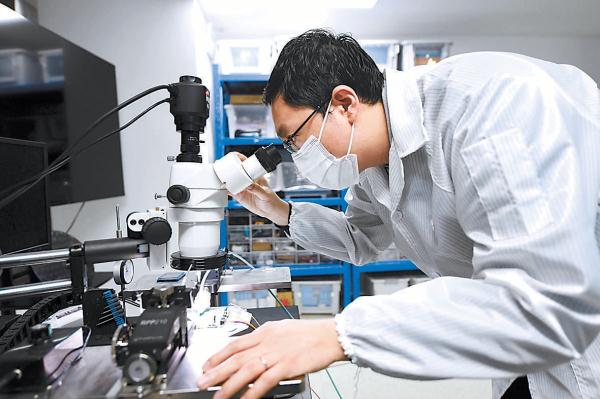 北京微芯区块链与边缘计算研究院，科研人员正在硬件实验室使用探针台对芯片进行性能测试。