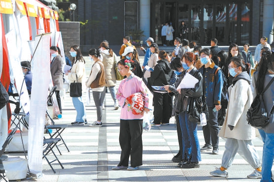 招聘会上，一位刚参加完演出还穿着戏服的学生，被河北梆子剧团的展板吸引。