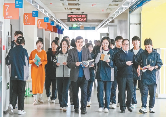 在北京八十中雄安容东分校，课间，北京教师胡永友（左四）为同学们答疑解惑。风趣的讲解，让教学楼里充满欢声笑语。