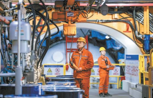 东六环改造工程西线隧道“京华号”盾构机掘进现场，项目建设者正在盾构机内吊装管片。