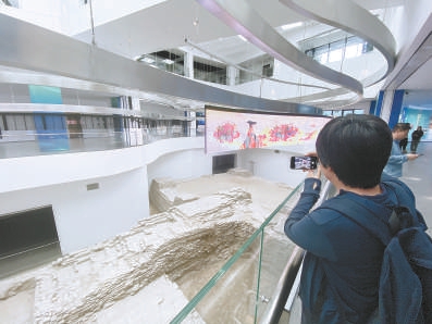 原址保护的通州古城墙遗址内嵌在北京市“两区”展示会客厅里，城墙上方就是现代感十足的电子显示屏。