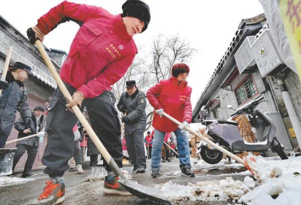 12月13日下午，东城区安定门街道宝钞南社区“铃铛扫雪队”清除胡同积雪。