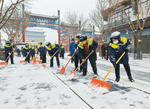 12月14日,前门步行街商户和环卫工人扫雪铲冰,方便游客出行。 12月14日,前门步行街商户和环卫工人扫雪铲冰,方便游客出行。