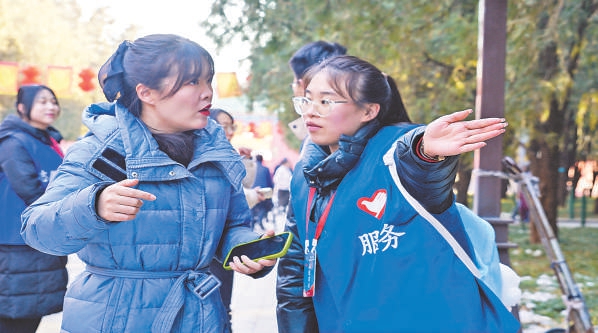 地坛庙会上，志愿者正为游客指路。