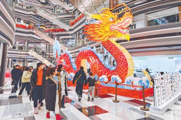 龙年春节假期，京城各大商圈节日氛围浓郁，顾客盈门。在王府井喜悦购物中心，龙型彩灯在中庭迎客。