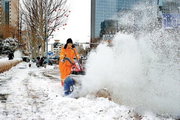 北京经济技术开发区科慧大道上，环卫人员使用扫雪机清理积雪，保障行人出行。