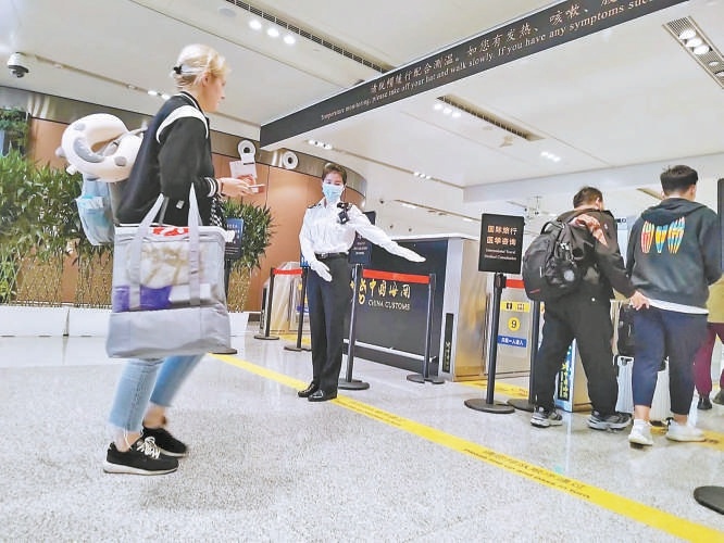 5月2日，大兴机场海关关员在旅检现场引导旅客快速通关。