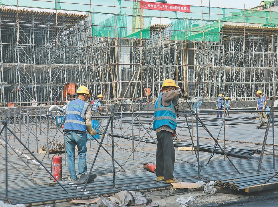 土桥立交基坑中，建设者正在焊接钢筋。