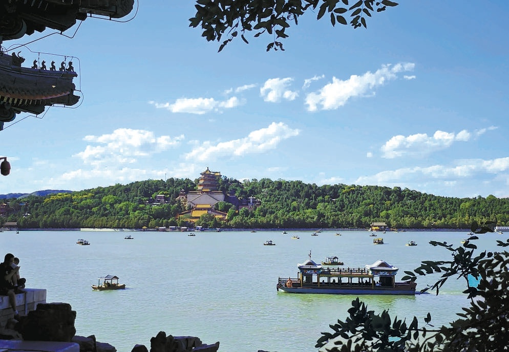 夏日的颐和园，蓝天白云，碧波荡漾，景观优美。游客漫步其间，仿佛置身桃花源中。