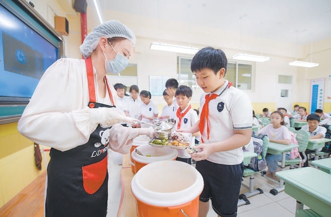 白家庄小学老师正在给学生发放餐食。