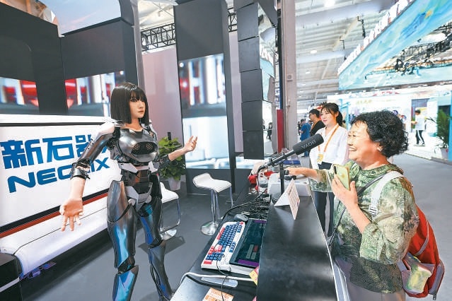 在首钢园展区，市民和智能机器人互动交流。