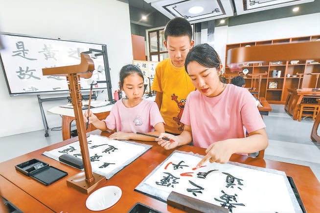 雄安史家胡同小学的书法教室，老师正在使用智慧书法系统指导学生练习书法。