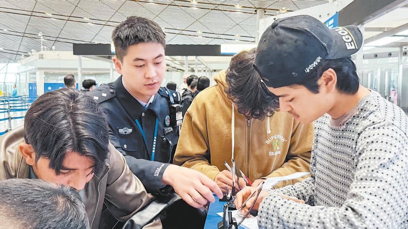 北京边检总站移民管理警察为旅客办理边检手续。