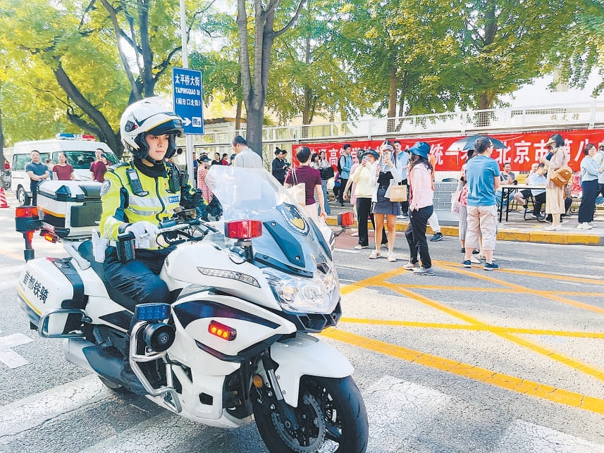 北京八中考点门前，西城铁骑女交警现场疏导交通。