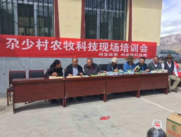 左新文（左二）在尕少村农牧科技现场培训会上。