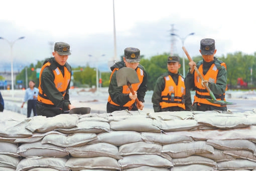 武警官兵在宁村新桥加固堤坝。
