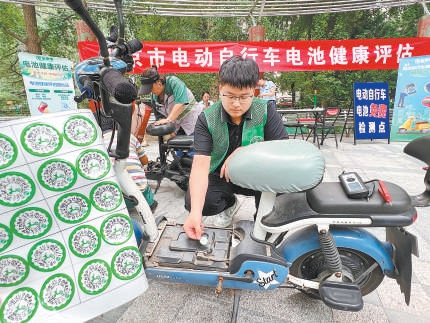 检测人员在给合格的电动自行车贴绿码。