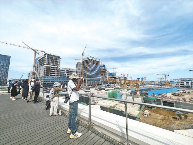 境内外记者登上东西轴线指挥调度中心的观景平台，俯瞰雄安城际站片区建设进展，远眺建设成果。