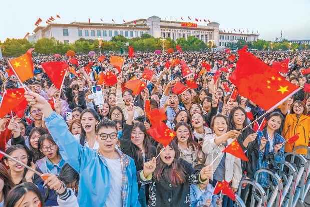 市民游客挥舞着五星红旗，祝祖国繁荣昌盛。