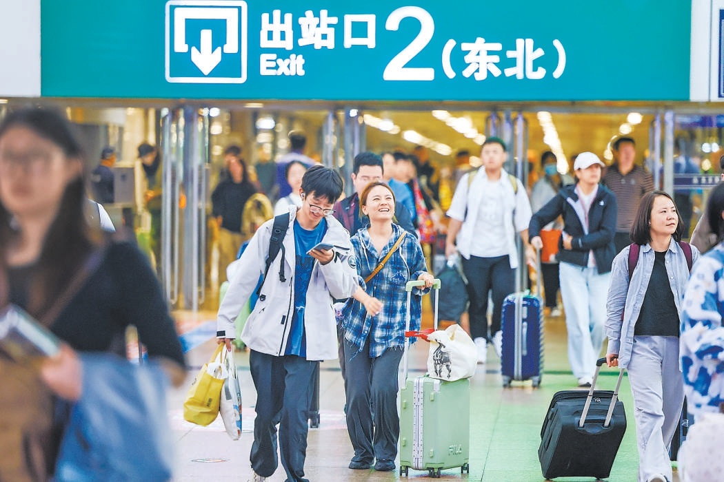 10月7日，假期返程高峰到来。在北京西站，返京旅客带着行李走出出站口。