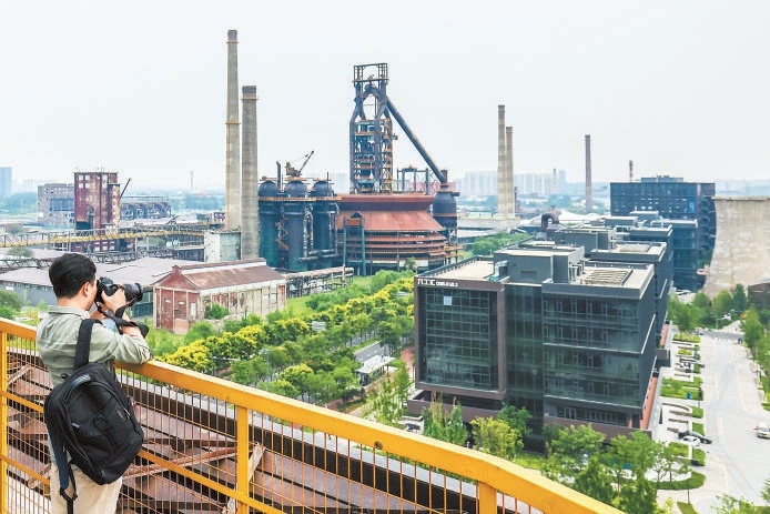游客在首钢园三高炉观景平台记录工业风美景。