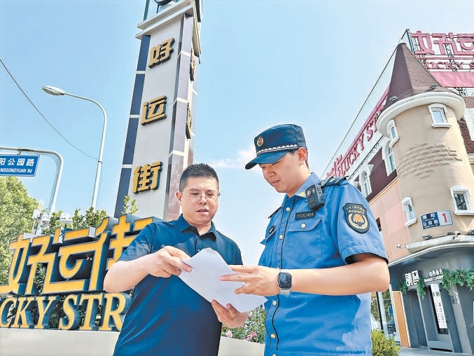 好运街街区,城管队员与物业人员沟通“门前三包”事项。 好运街街区,城管队员与物业人员沟通“门前三包”事项。