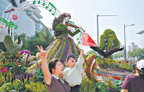昨天,市民在西单路口东南角的立体花坛前留影。 昨天,市民在西单路口东南角的立体花坛前留影。