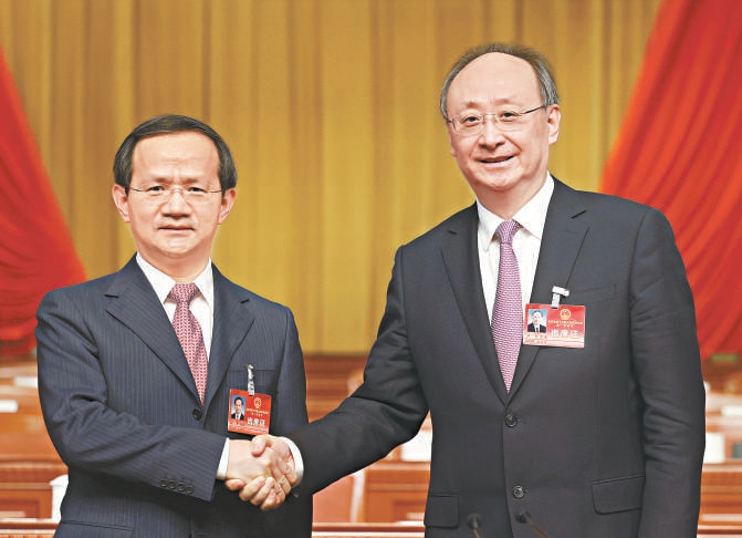 尹力同志（右）与新当选的北京市市长殷勇同志（左）亲切握手。