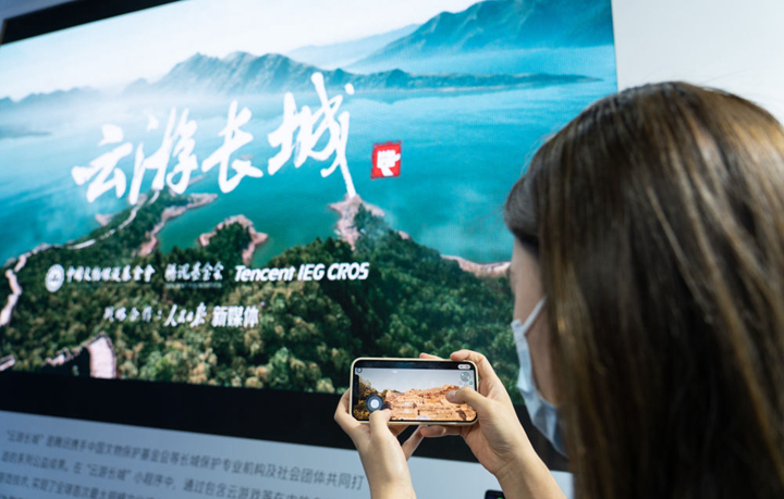 在北京举行的2022全球数字经济大会上，一名工作人员在元宇宙体验馆展示“云游长城”小程序（2022年7月28日摄）。