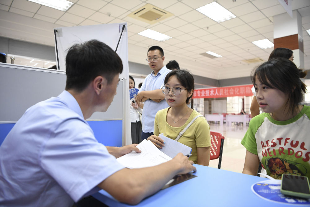 2023年7月29日，“扬就业之帆，启梦想之旅”2023年宁夏（银川）离校未就业高校毕业生招聘会在宁夏（银川）人力资源服务产业园举行。求职者（右）在招聘会现场与用人单位交流。