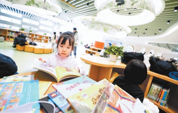 北京城市图书馆，小读者认真读绘本。