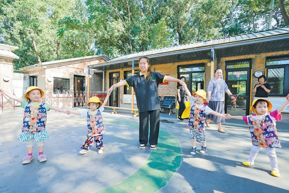 7月17日，海淀区石油共生大院的鸿萌托育园里，孩子们在老师陪伴下快乐游戏。