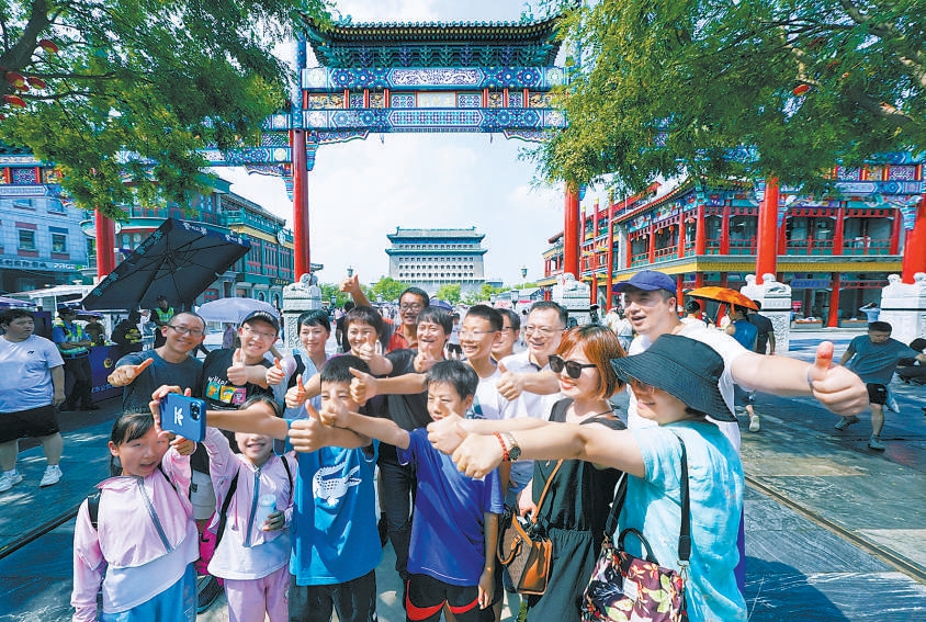 7月27日，游客在前门步行街自拍打卡，为北京中轴线申遗成功点赞，记录下难忘时刻。