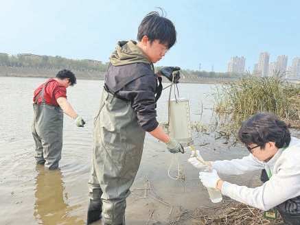 学生们相互配合收集水样。