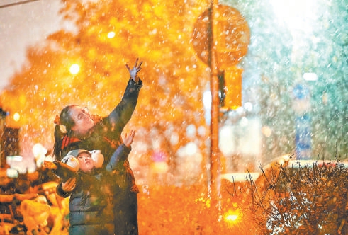 昨天，新年初雪飘落京城，在东单附近的胡同里，一对母女兴奋地与雪花共舞。