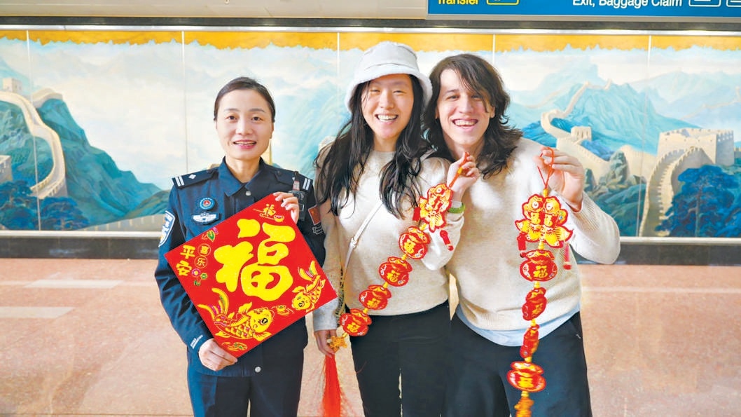 外国游客在首都机场获赠新春福字挂饰。 外国游客在首都机场获赠新春福字挂饰。