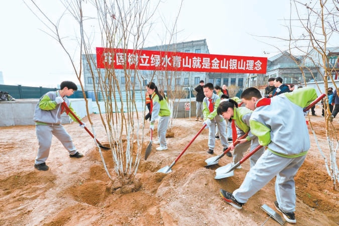 日前，在前门月亮湾绿地，各界代表和青少年共同参加植树，为北京再添新绿。