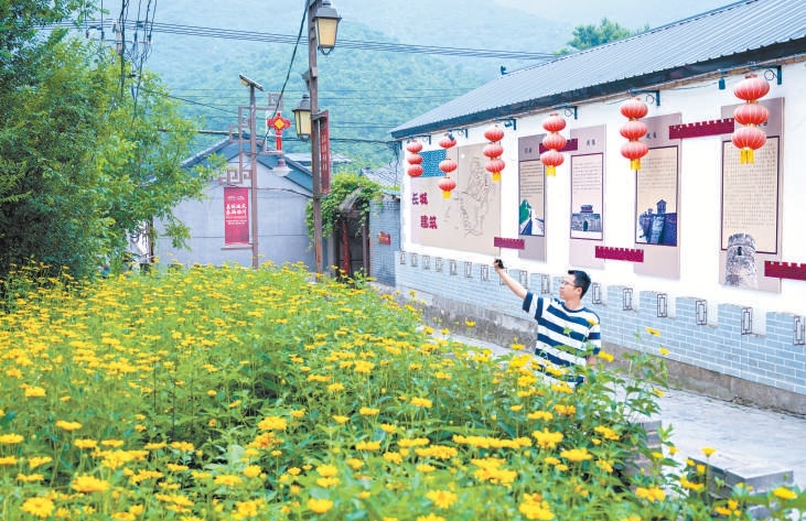 延庆区石峡村绿意盎然、鲜花盛放，街巷整洁有序，长城文化墙文化气息浓厚，勾勒出一幅生态美、文化兴的乡村振兴新画卷。