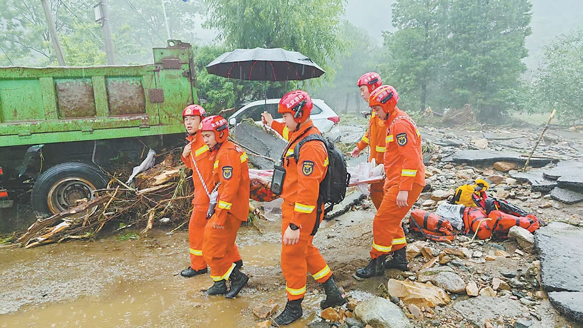 顺义消防员增援密云，在石城镇高家岭村转移一名行动不便的被困群众。