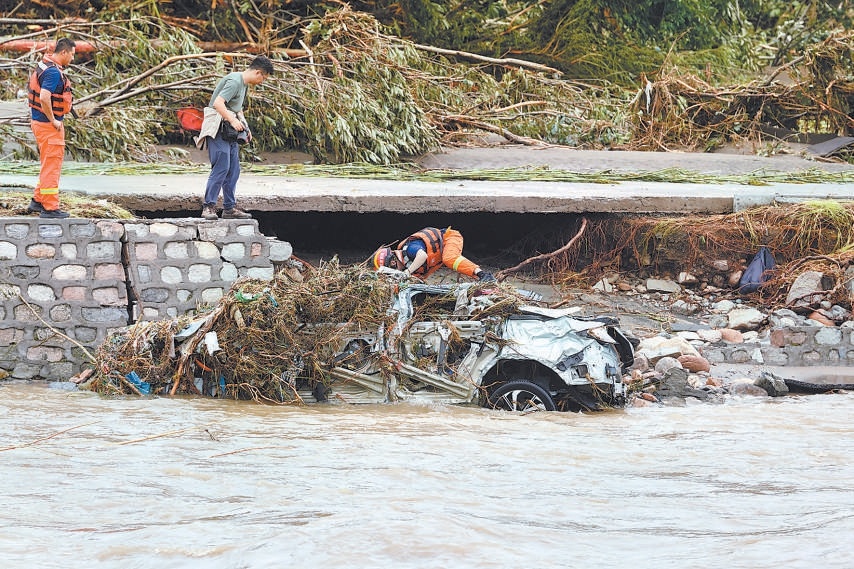 密云区冯家峪镇水峪沟门附近，洪水将一辆汽车冲进白马关河道里，消防救援人员前去查看是否有人员被困。